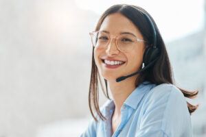 A smiling woman with a headset on.